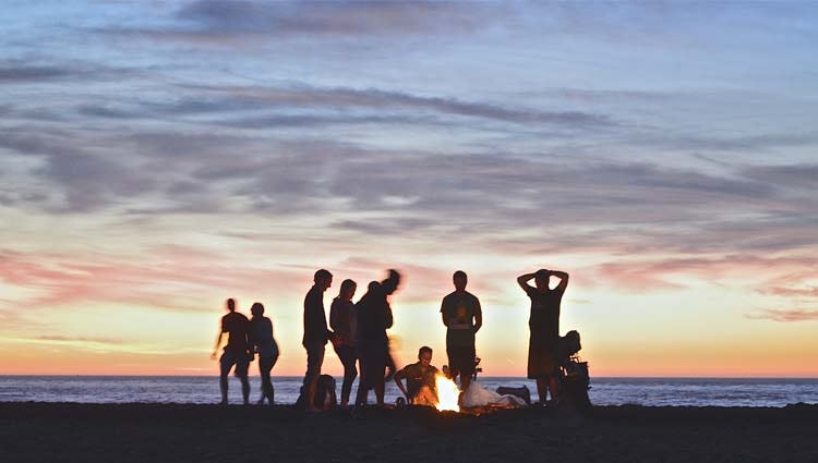 Sitting around a camp fire on a beach